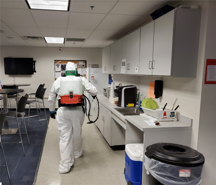 man wearing cleaning suit in office